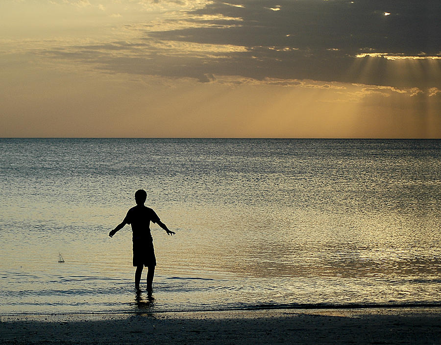 Young Boy Skipping Stones at Bonita Beach Photograph by Ginger Wakem