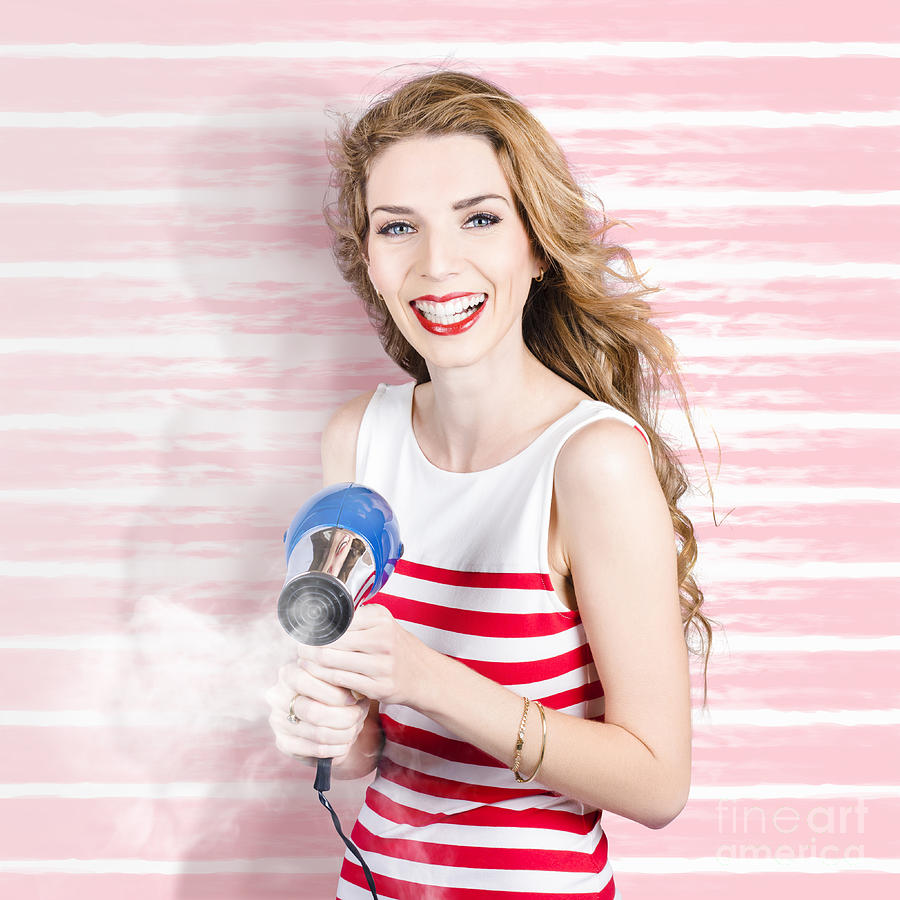 Smiling stylist with hair dryer at beauty salon Photograph by Jorgo Photography