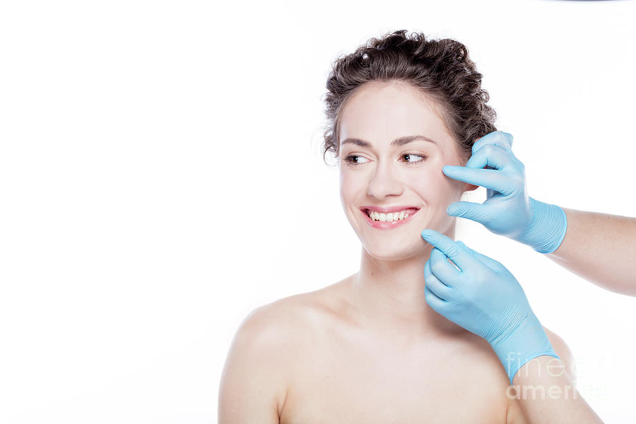 Smiling woman having skin checkup before plastic surgery. Photograph by Michal Bednarek