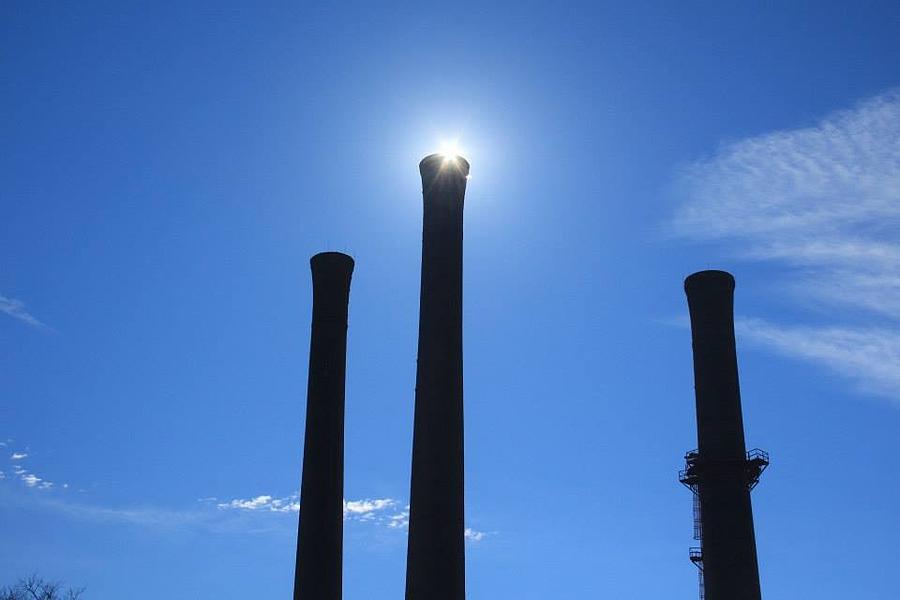 Smoke Stacks Photograph - Smoke stacks highlighted by the Sun by Bill Setliff