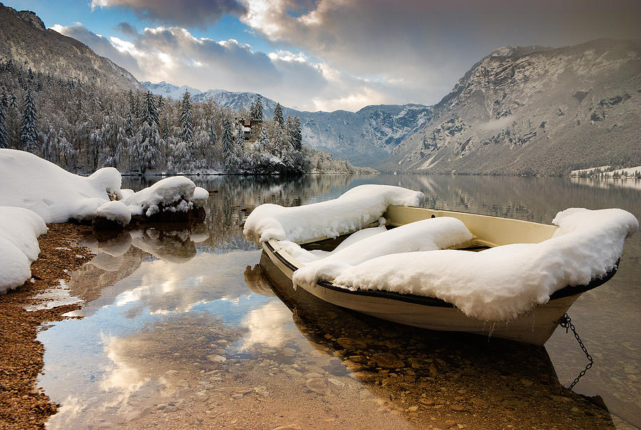 Snow covered boat on Lake Bohinj in Winter Photograph by Ian Middleton