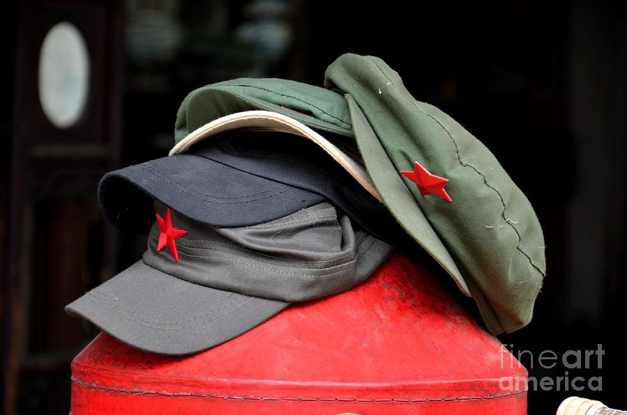 Stack of communist Mao style caps with red star Photograph by Imran Ahmed