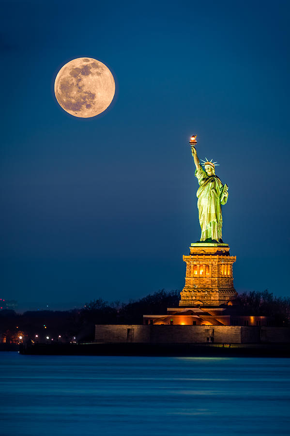 Statue of Liberty and a rising supermoon in New York City Photograph by Mihai Andritoiu
