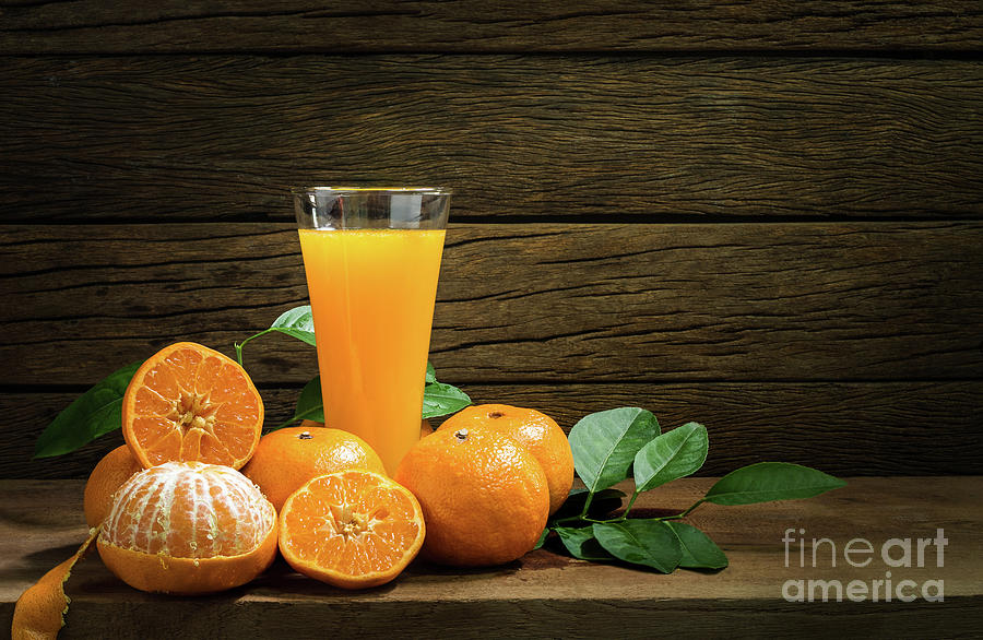 A glass of orange juice on a table in a blue interior. Stock Photo by  puhimec