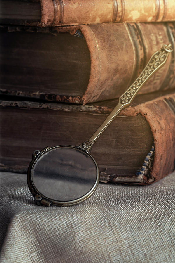 Still life with old books and brass loupe Photograph by Jaroslaw Blaminsky