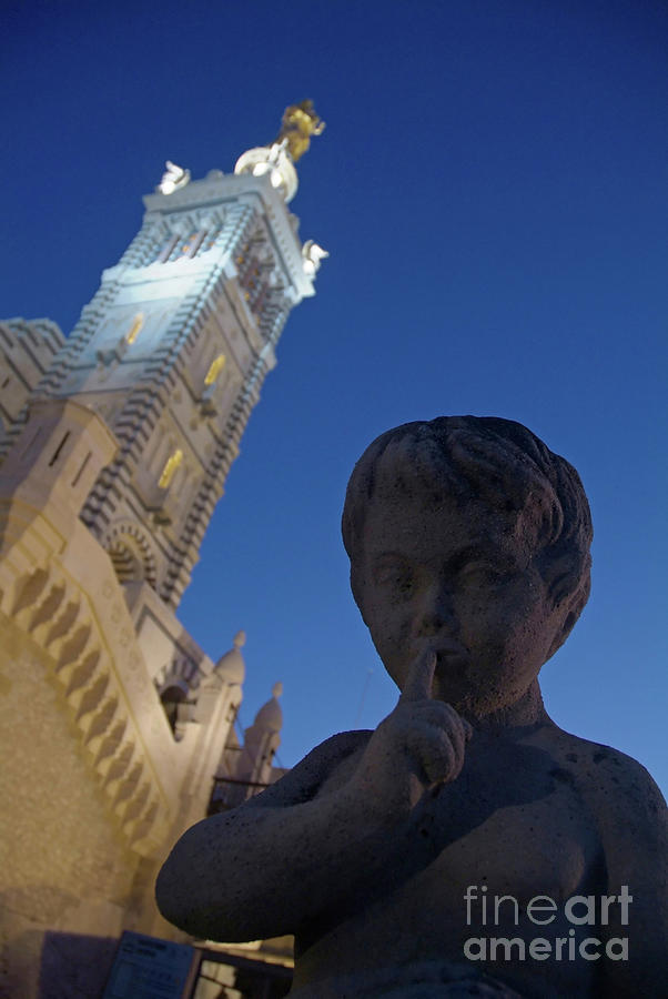 Stone statue of a cherub with view of the bell tower of Notre Dame de la Garde in Marseille Photograph by Sami Sarkis