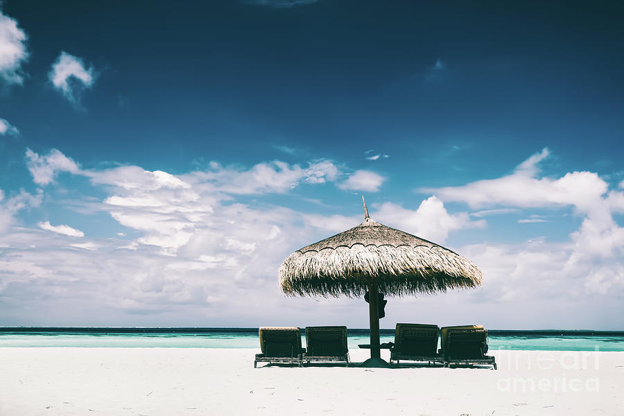 Straw umbrella and sunbeds on a sandy beach Photograph by Michal Bednarek
