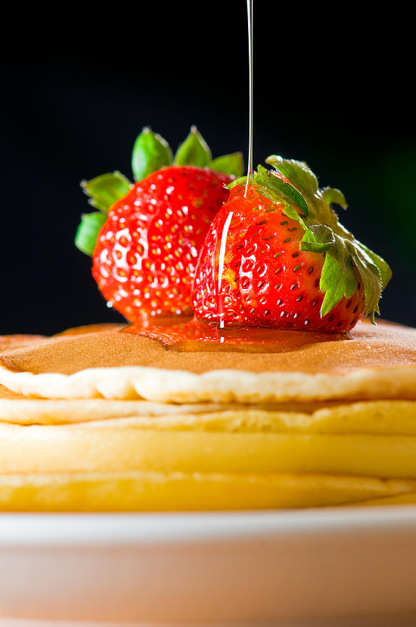Strawberry butter pancake with honey maple sirup flowing down Photograph by U Schade