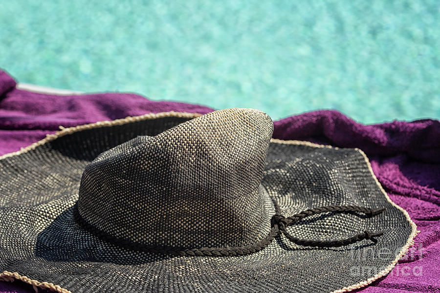 Sun hat lying on a towel near the pool Photograph by Patricia Hofmeester