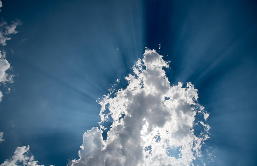 Sun rays behind white clouds Photograph by Michalakis Ppalis