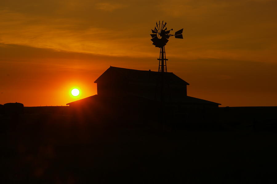 Sunrise on an old barn and windmill Photograph by Jeff Swan