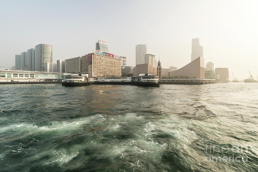 Sunrise over the Kowloon skyline with the Star Ferry pier and th Photograph by Didier Marti