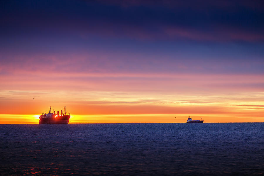 Sunrise over the sea with sailing cargo ship Photograph by Valentin ...