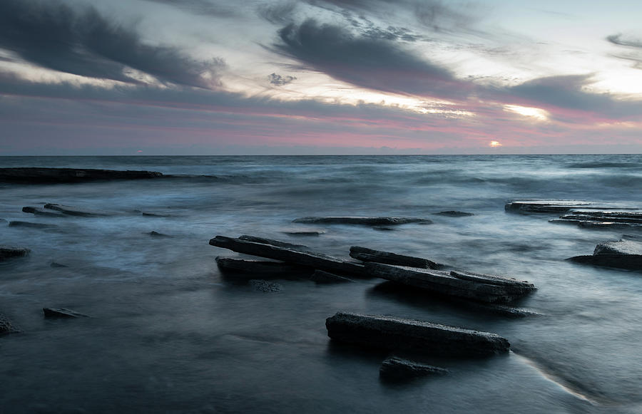 Sunset on a rocky beach Photograph by Michalakis Ppalis