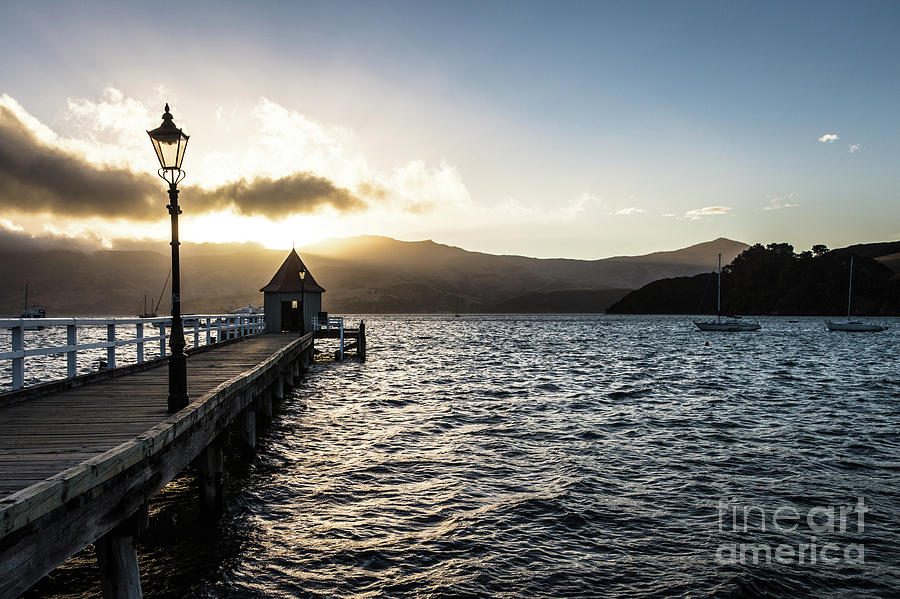 Sunset over the jetty in Akaroa, New Zealand Photograph by Didier Marti