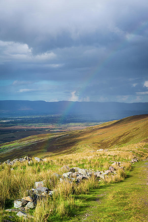 Sunshine and raining down with rainbow on the countryside in Ire Photograph by Semmick Photo