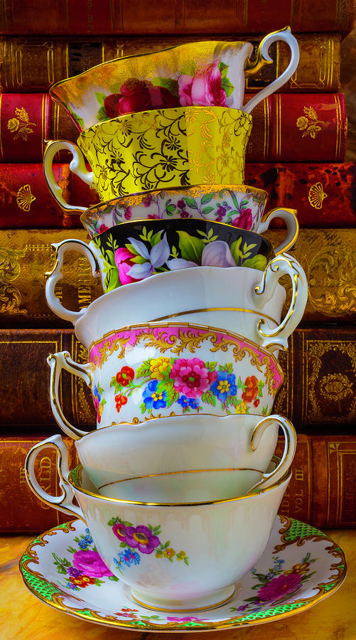 Flower Photograph - Tea Cups Stacked Against Old Books by Garry Gay