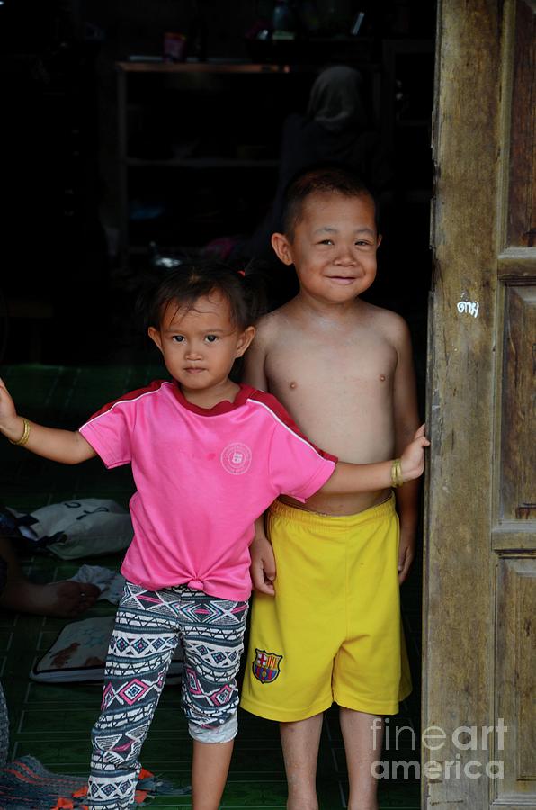 Thai brother and sister at doorway in fishing village Pattani Thailand Photograph by Imran Ahmed