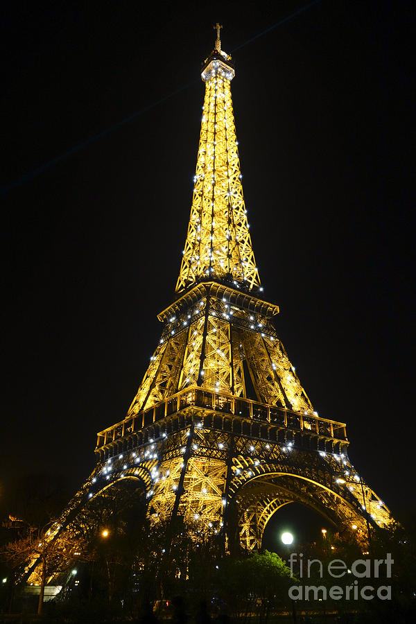 The Eiffel tower at night illuminated, Paris, France. Photograph by Perry Van Munster