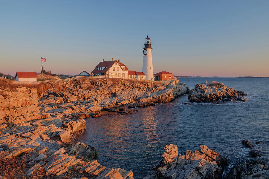 The first rays of sunrise hits the Maine Coast turning the Rocks ...