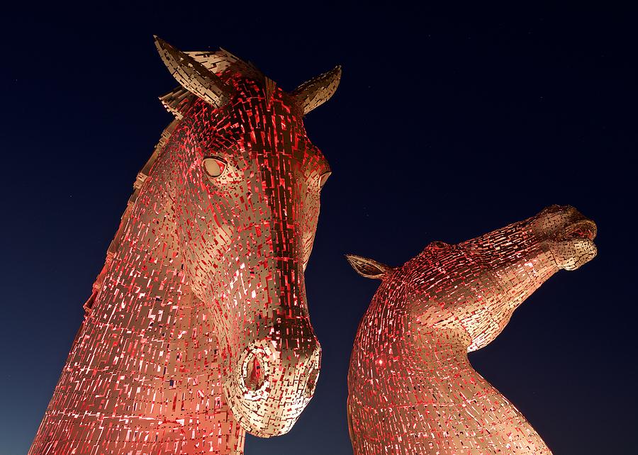 The Kelpies illuminated red Photograph by Stephen Taylor