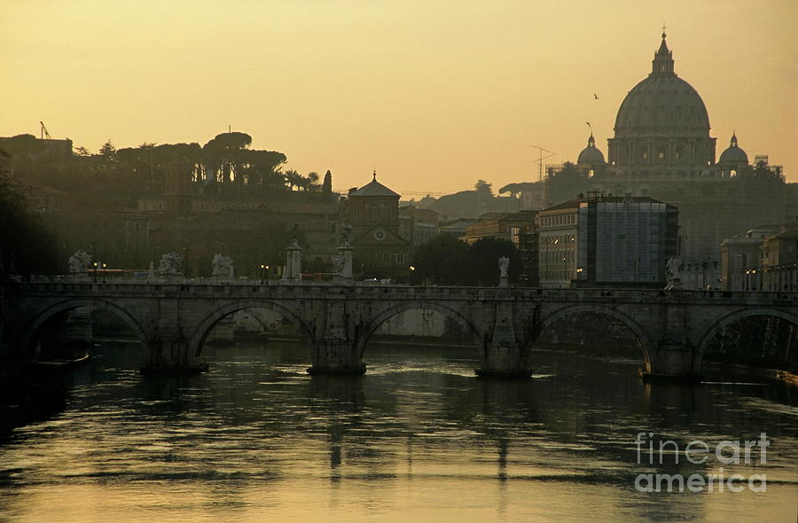 The Sant Angelo Bridge and the Papal Basilica of Saint Peter at sunset in Vatican City Photograph by Sami Sarkis