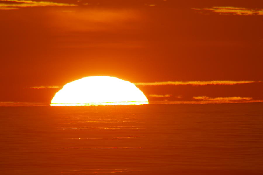 Sunset Photograph - The sun sinking into the ocean by Jeff Swan