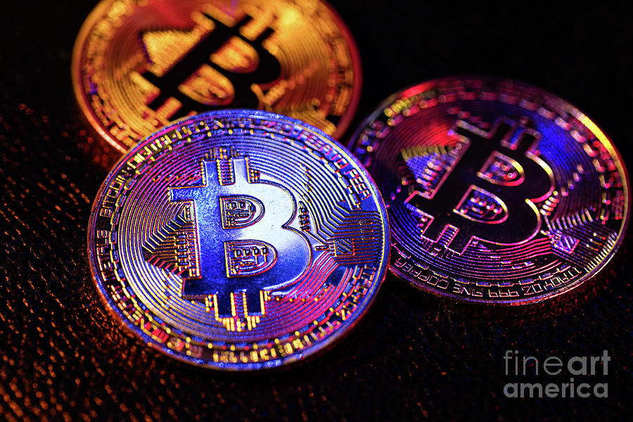 Three coins with bitcoin logo laying on a black background Photograph by Michal Bednarek