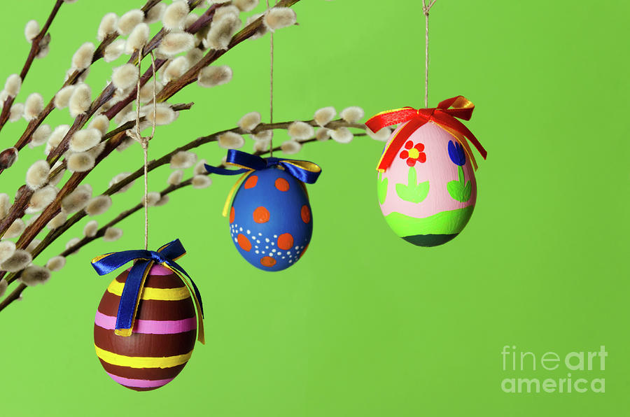 Three colored easter eggs on willow bouquet with pussy willows