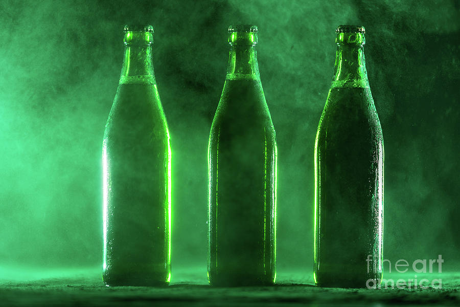 Three Green Beer Bottles On A Dusty Background. Photograph