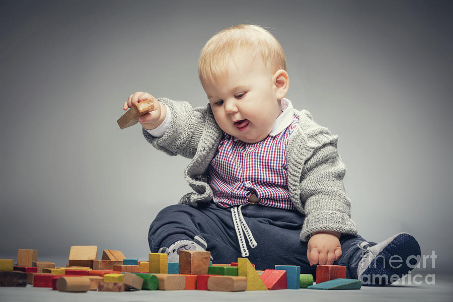 Toddler boy playing with building blocks. Photograph by Michal Bednarek