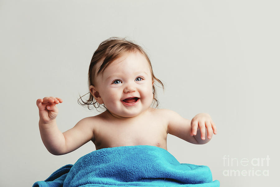 Toddler With A Cozy Blanket Sitting And Smiling. Photograph