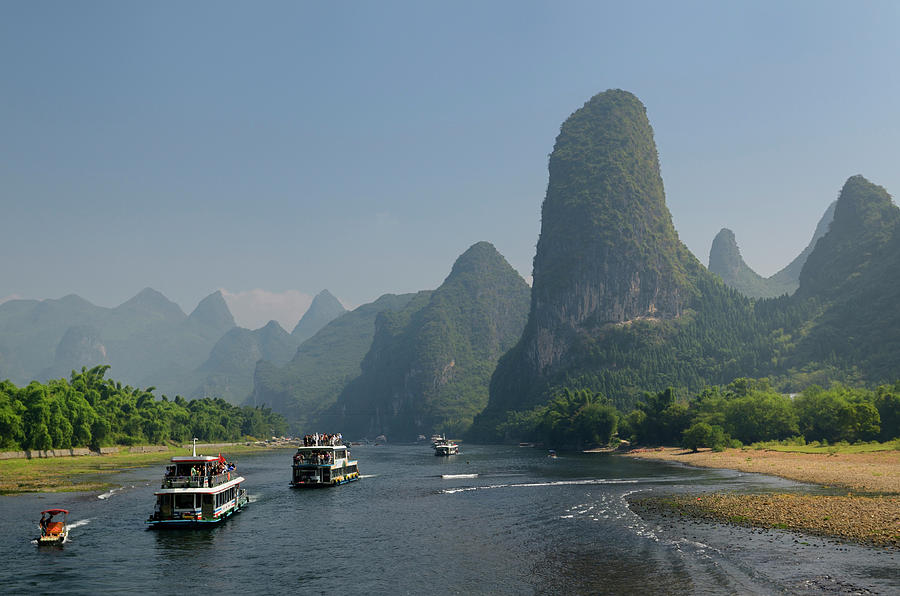 Tour boats traveling down the Li river Guangxi China with tall k ...