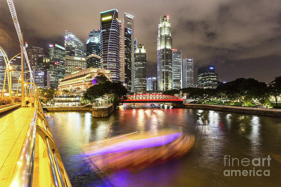 Tourboat rush on Singapore river at night in business district.  Photograph by Didier Marti