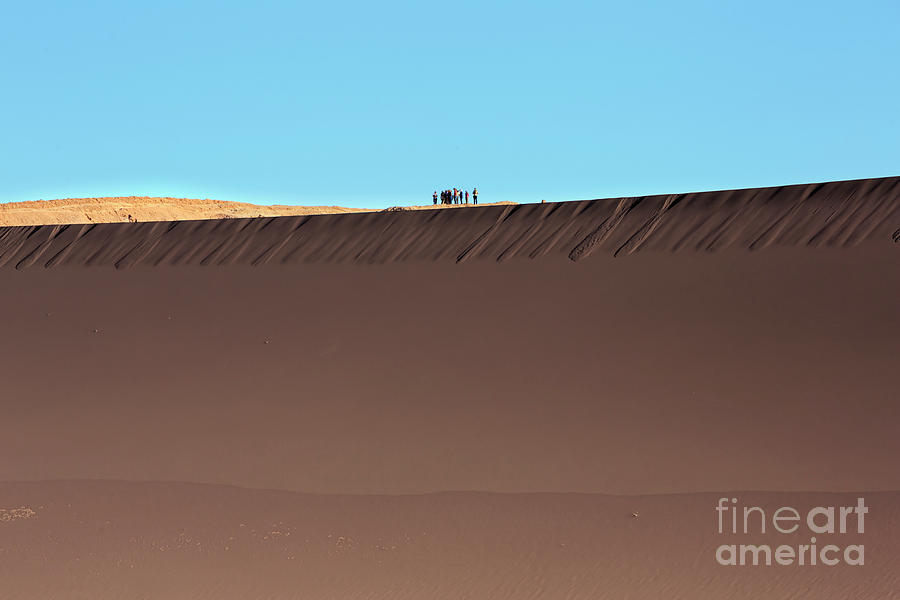 Tourists stand on top of a sand dune in Valle de la Luna Photograph by Louise Heusinkveld