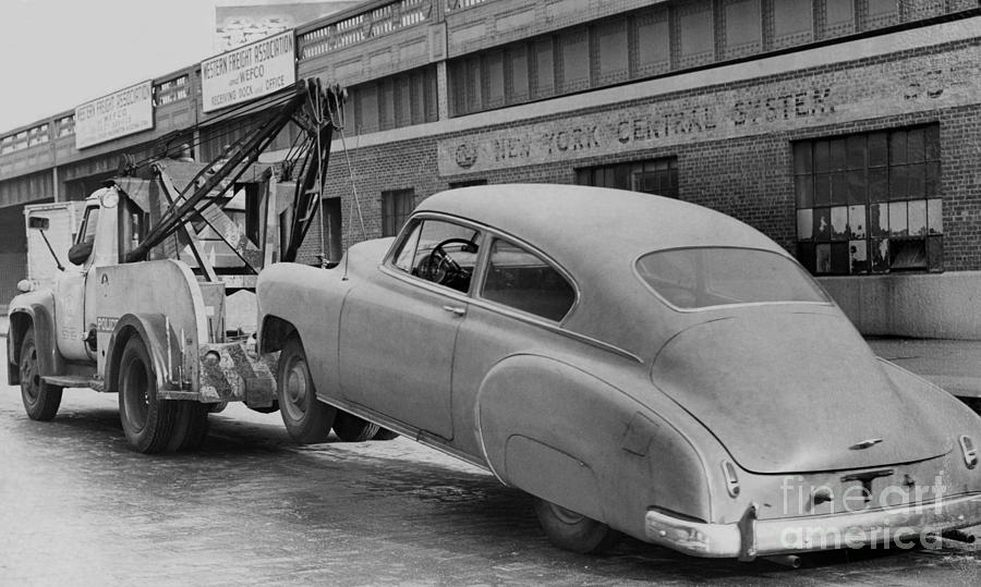 Tow Truck hooks onto a 1950's Model Chevrolet. 1961 by Barney Stein