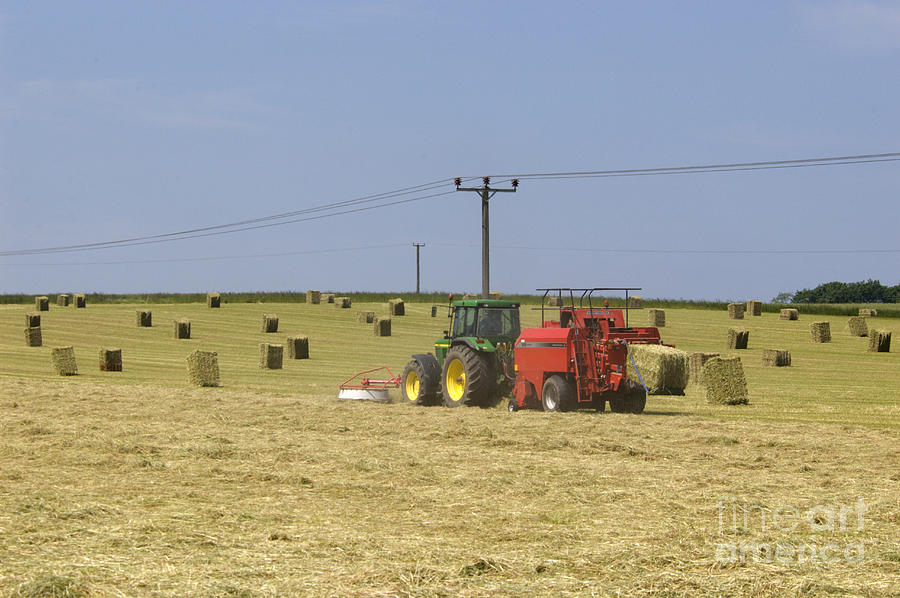 Summer Photograph - Tractor bailing hay in a field at harvest time by Andy Smy
