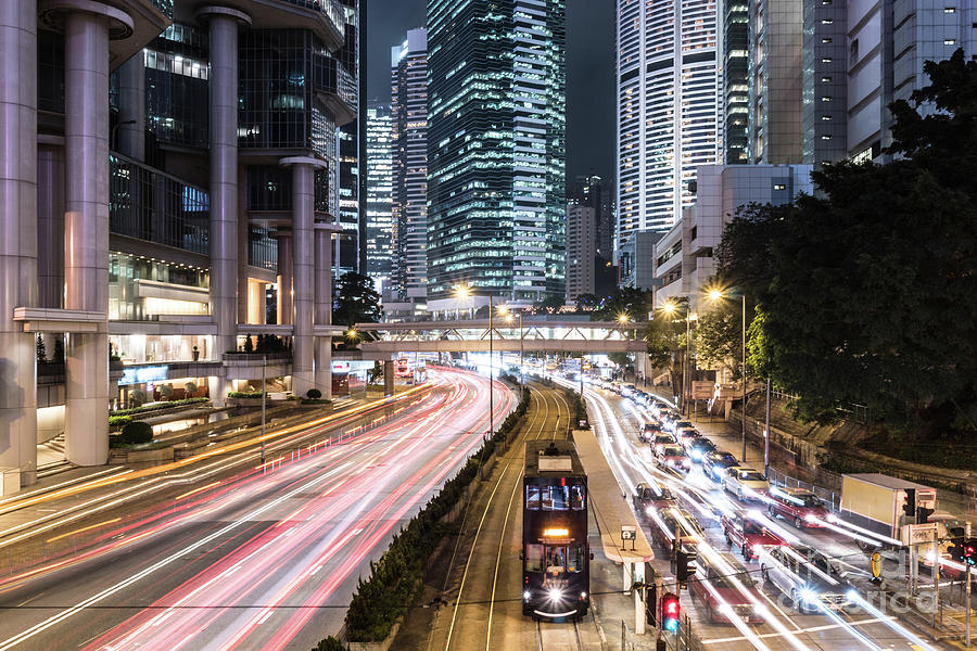 Traffic rushing in Hong Kong island while a tram car wait. Photograph by Didier Marti
