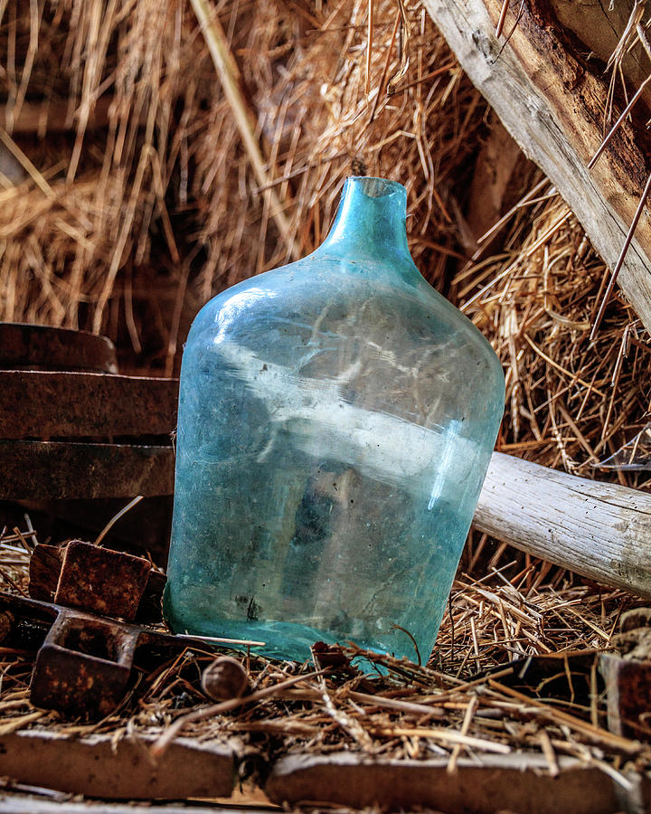 Architecture Photograph - Turquoise glass bottle in hay by Emily M Wilson