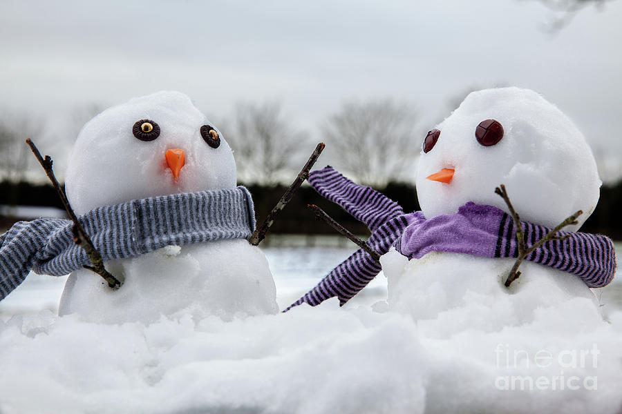 Two cute snowmen wearing scarfs and twigs for arms Photograph by Simon Bratt