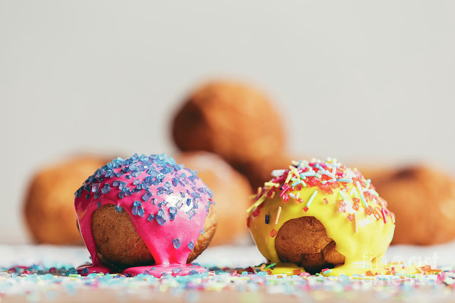 Two decorated doughnuts laying on a table. Photograph by Michal Bednarek