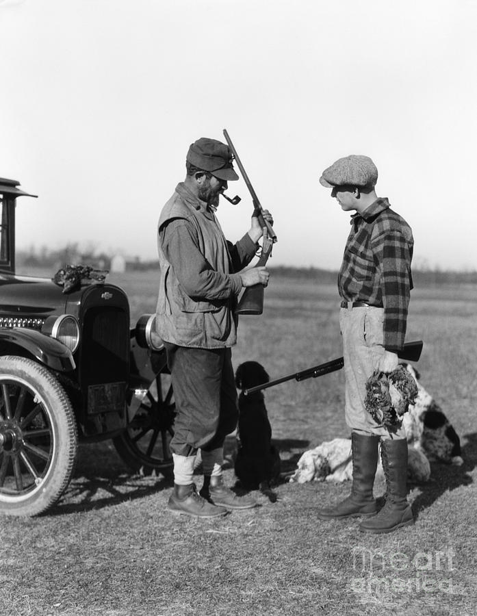 Two Hunters Looking At Shotgun, C.1930s Photograph by H. Armstrong Roberts/ClassicStock