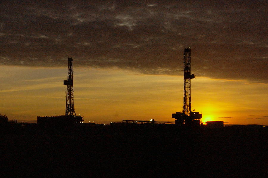 Dawn Photograph - Two oil rigs at sunrise by Jeff Swan