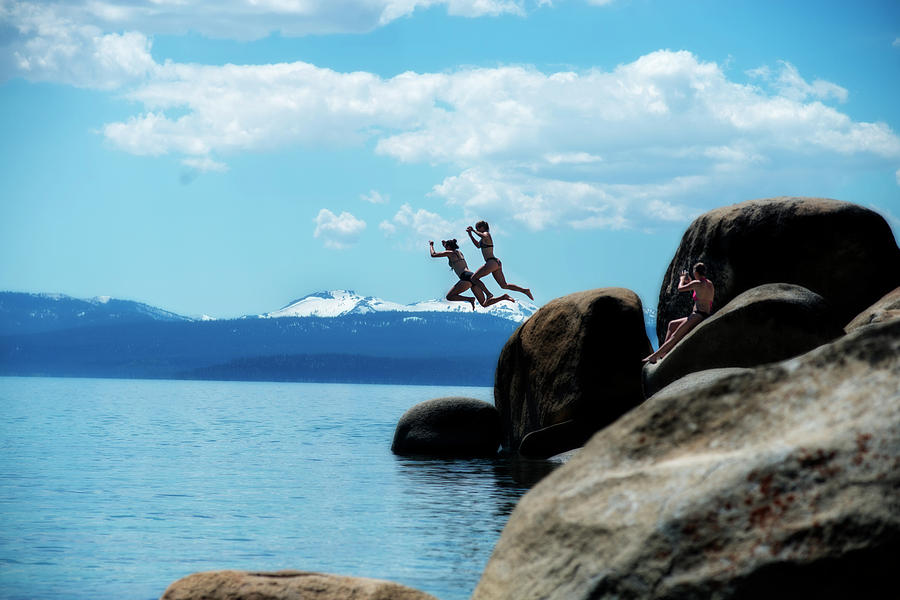 Two people jumping into the cold water of Lake Tahoe Photograph by Dan Friend