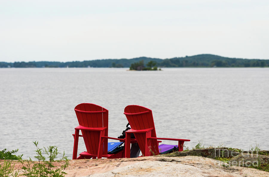 Two red chairs at a lake Photograph by Les Palenik