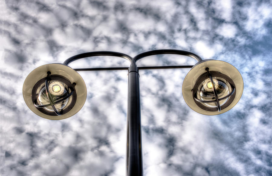 Two Streetlamps Under A Cloudy Sky Photograph by Gary Slawsky