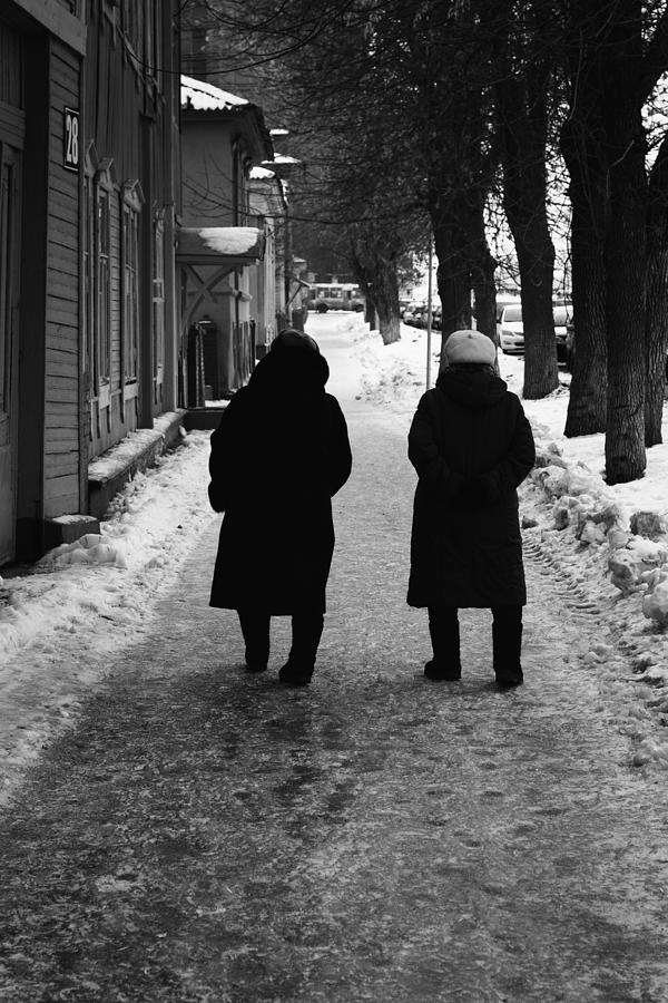 Two Women in Winter Clothes Walking Away Photograph by John Williams
