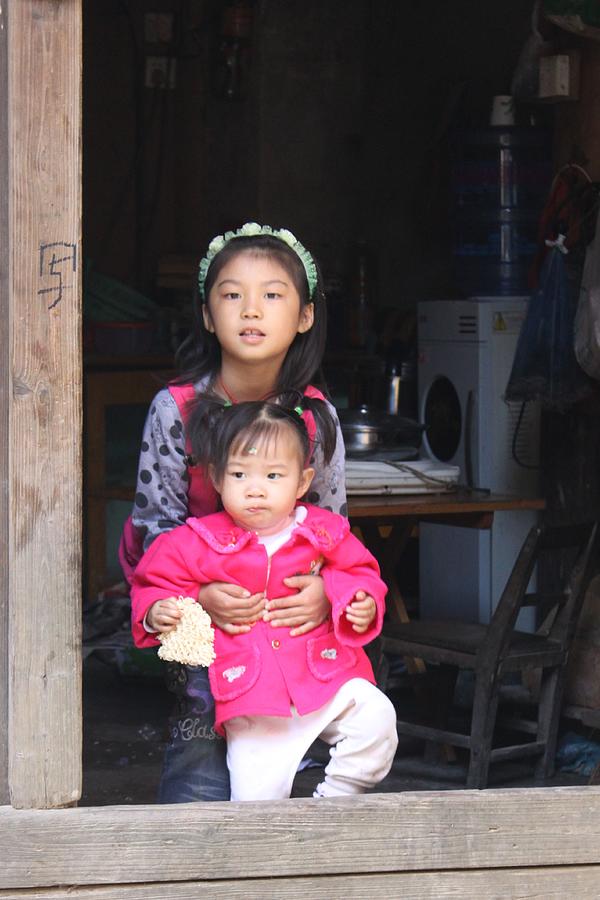 Two young Chinese girls in door of hutong house Photograph by Thomas Marchessault