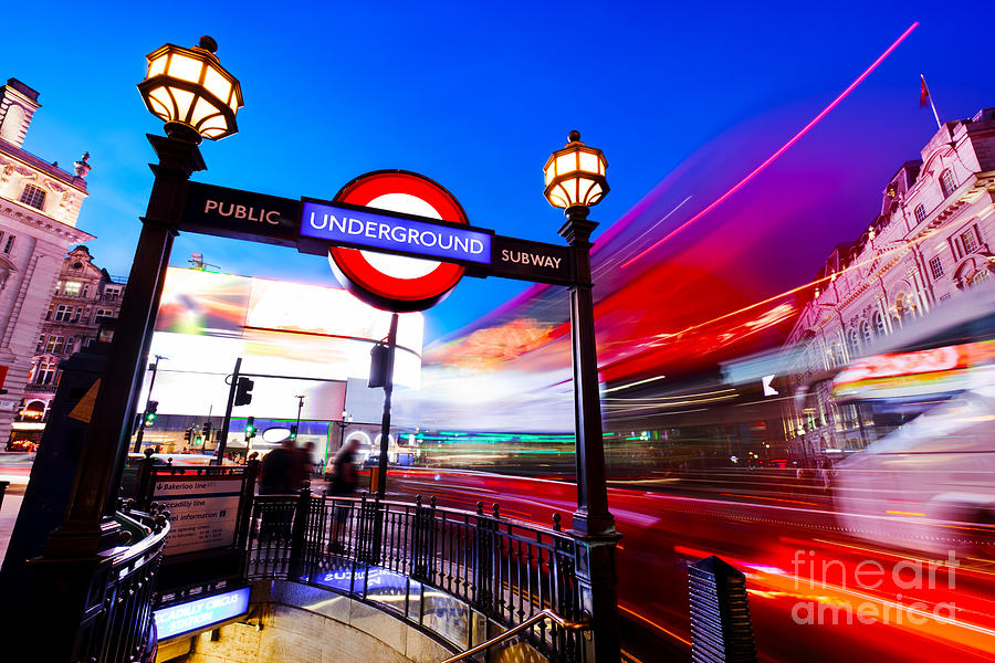 Underground sign, red bus in motion on Piccadilly Circus. London, UK at night Photograph by Michal Bednarek