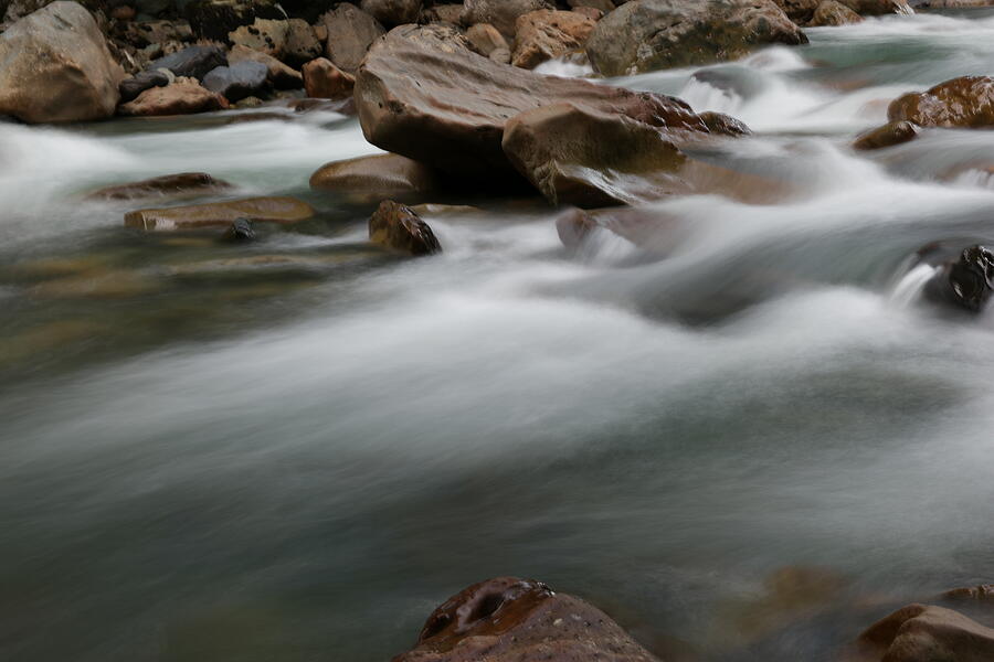 Upturned rock in a flowing stream Photograph by Jeff Swan